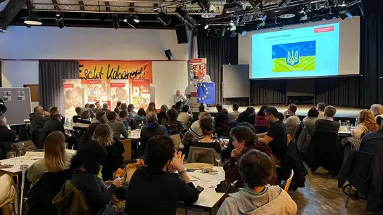 Das Foto zeigt die Teilnehmer*innen und Hildegard Höhfeld-Kalter am Podium beim 10. Terre des Hommes-Quizabend in Köln Ehrenfeld.