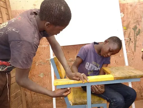 Mali: Zwei Jungen lösen gemeinsam eine Aufgabe im Schreiner-Handwerk.
